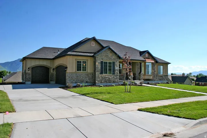 Stone and siding exterior with a dark shingle roof