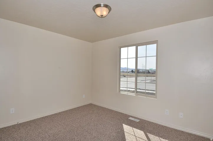 Neutral-toned walls, textured ceiling, and a flush mount ceiling fixture
