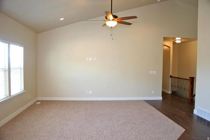 Vaulted ceilings, recessed lighting, and a ceiling fan with integrated light fixture