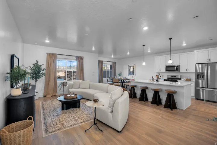Open-concept living space featuring wood-finish flooring, recessed lighting, and a kitchen island with pendant lighting