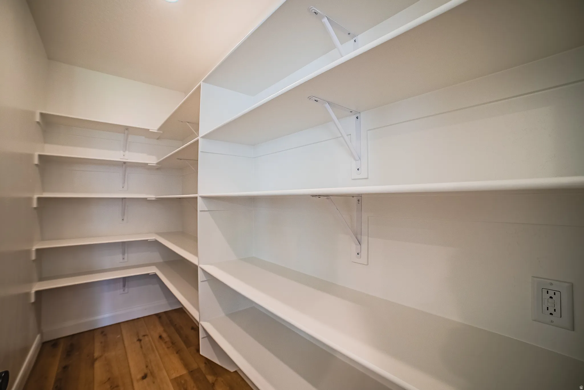 Built-in white shelving, recessed lighting, and wood-finish flooring