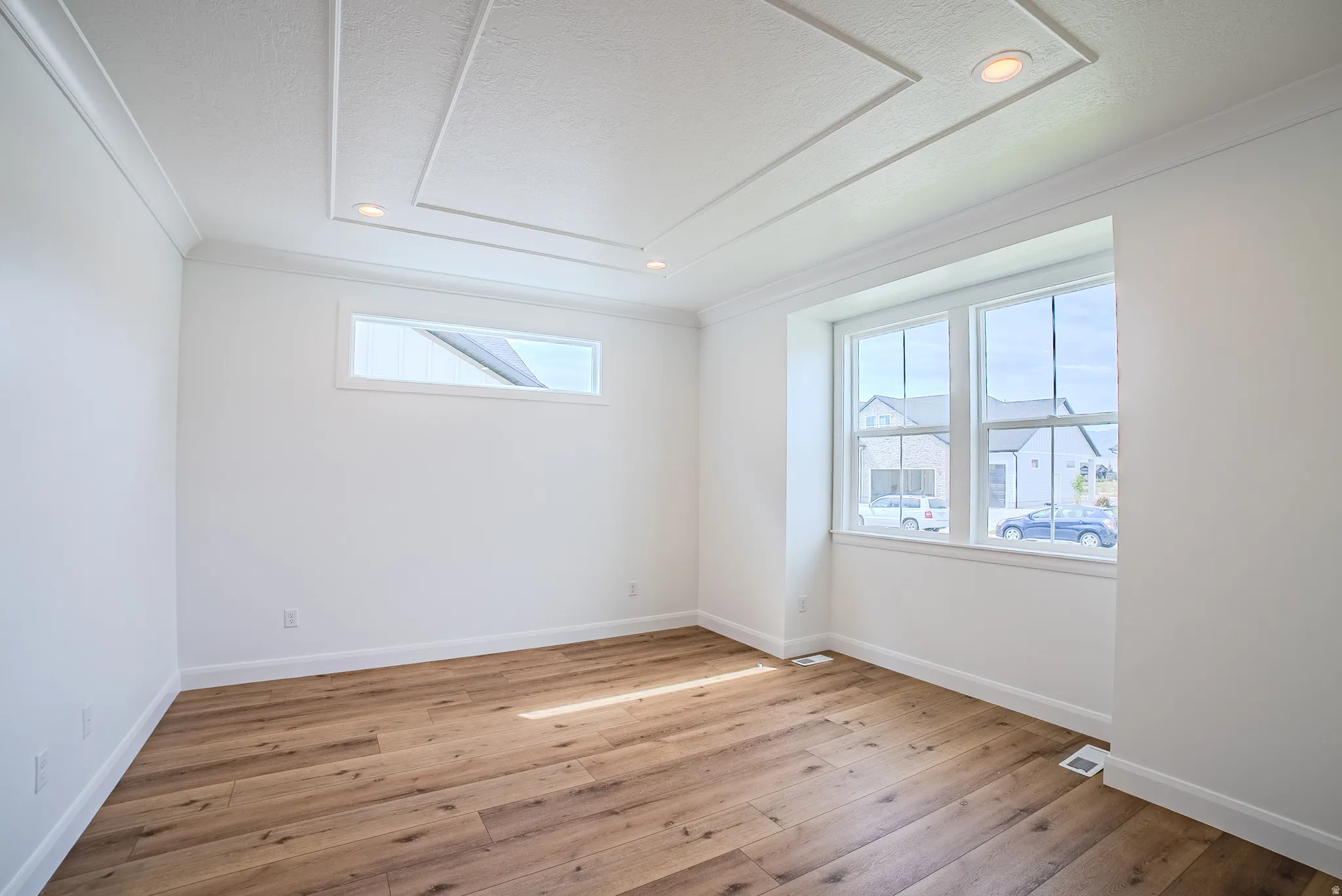 Coffered ceiling with recessed lighting, wood-finish flooring, large multi-pane window, and high rectangular accent window