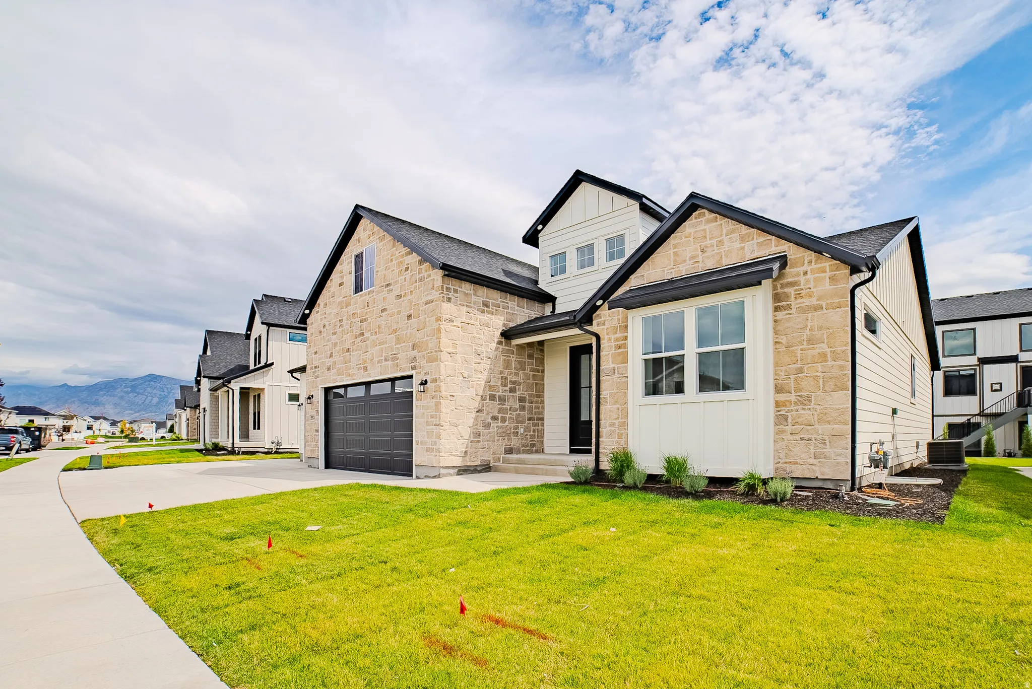Stone and board-and-batten exterior with a dark-paneled garage door