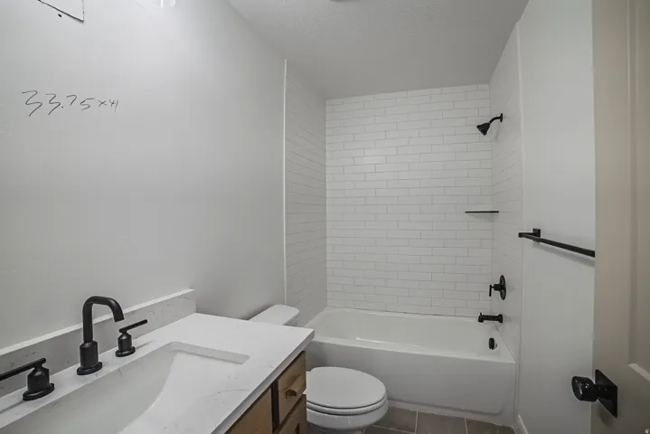 White subway tile shower surround with black fixtures