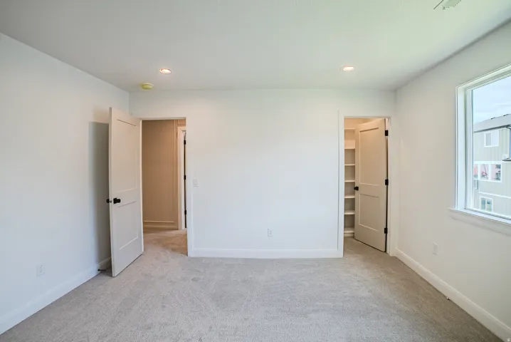 Carpeted flooring, recessed lighting, white trim, and a window with a white frame