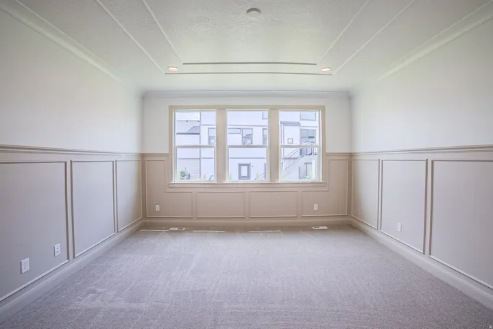 Tray ceiling with recessed lighting, crown molding, wainscoting, large windows, and carpet flooring