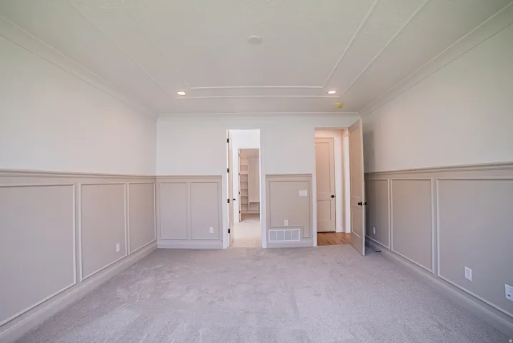 Recessed lighting illuminates the coffered ceiling, complementing the two-tone wainscoting and wall trim