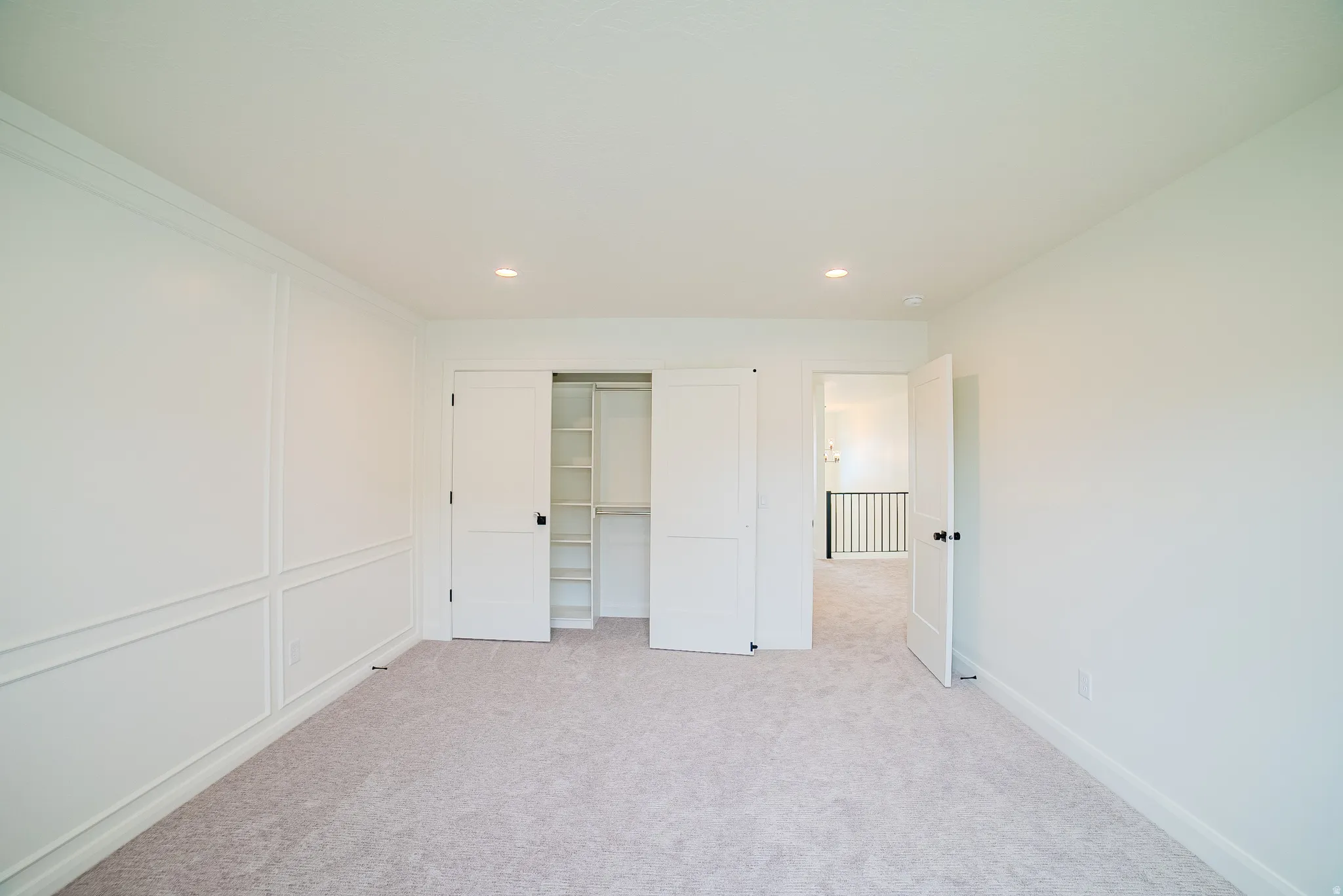 Recessed lighting illuminates fresh carpeting and custom wall paneling