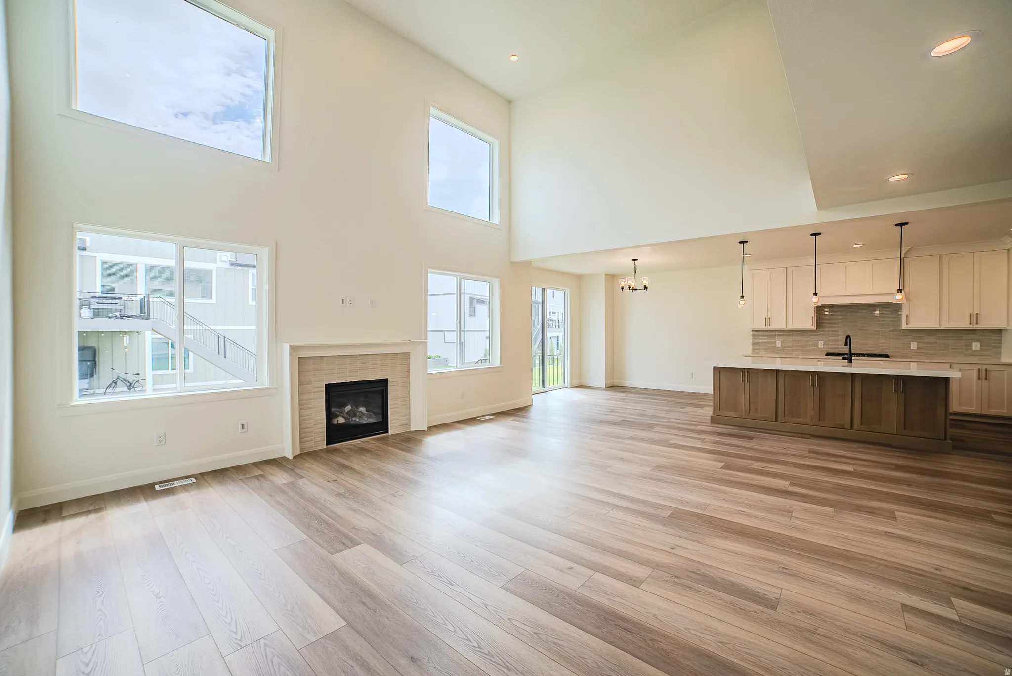 Vaulted ceilings, wood-finish flooring, and a fireplace with a stone surround