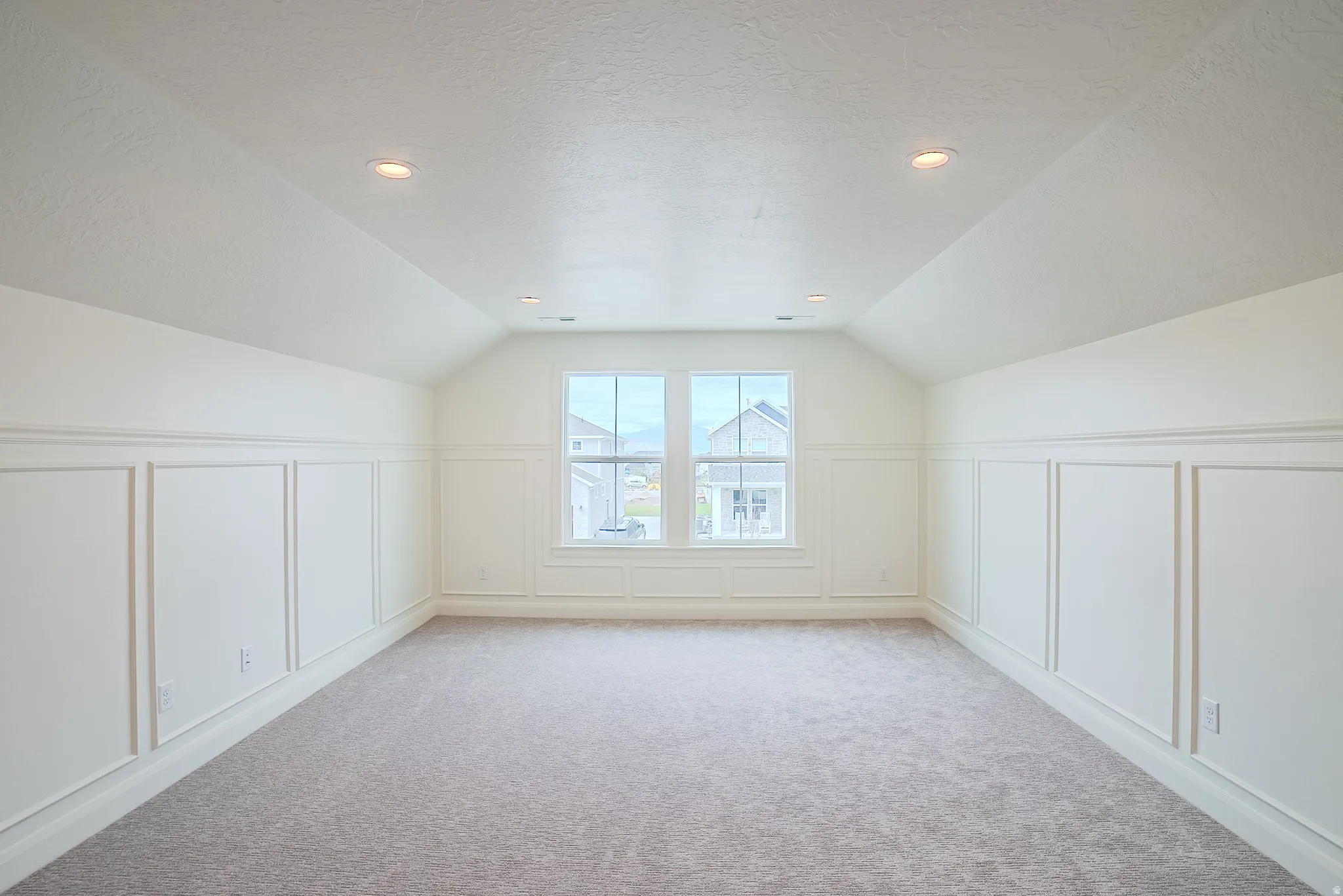 Carpeted room featuring wainscoting, recessed lighting, and a dual-pane window