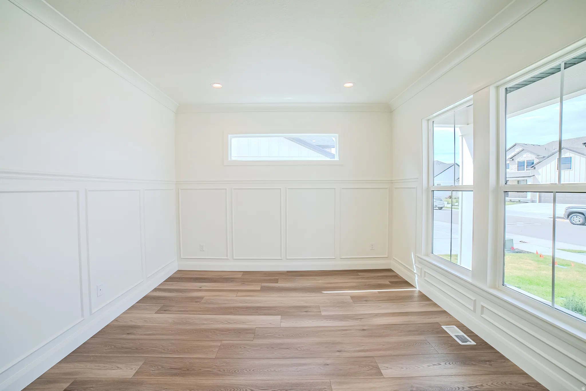 Crown molding, recessed lighting, wood-finish flooring, wainscoting, and large windows