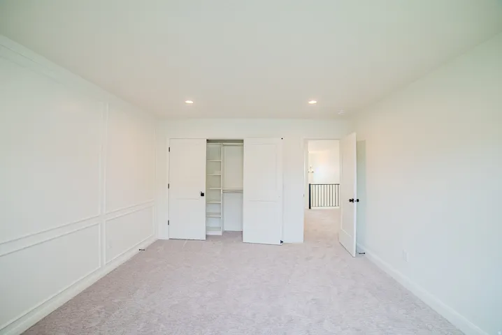 Recessed lighting illuminates fresh carpeting and custom wall paneling
