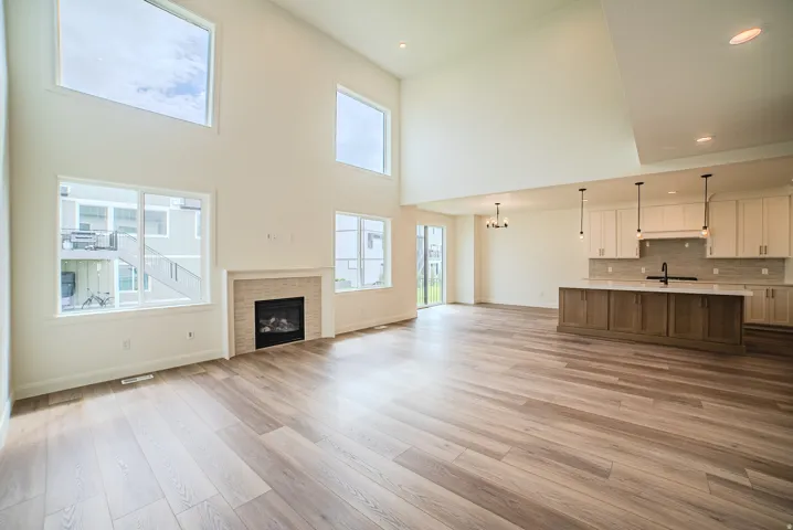 Vaulted ceilings, wood-finish flooring, and a fireplace with a stone surround