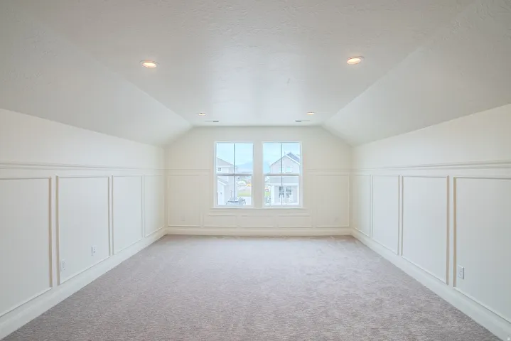 Carpeted room featuring wainscoting, recessed lighting, and a dual-pane window