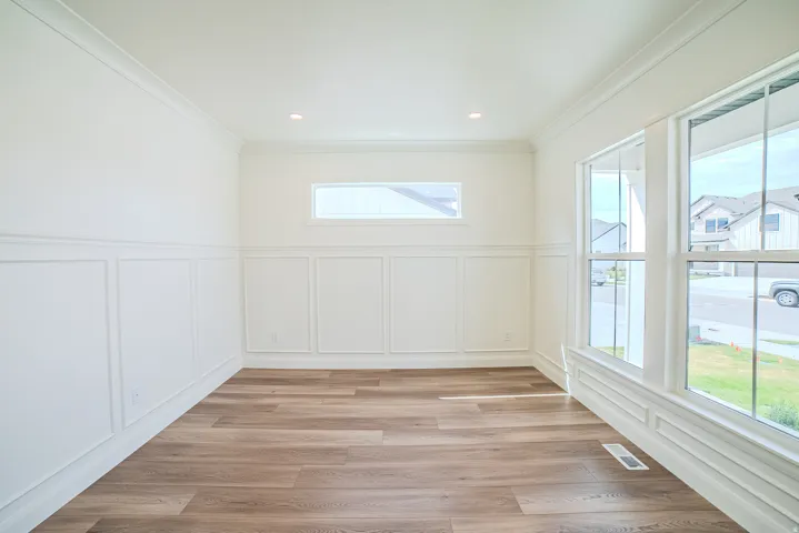 Crown molding, recessed lighting, wood-finish flooring, wainscoting, and large windows