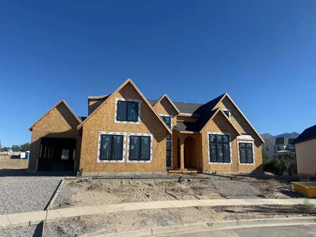 New construction residence featuring a multi-gable roofline, arched entry, and a two-car garage