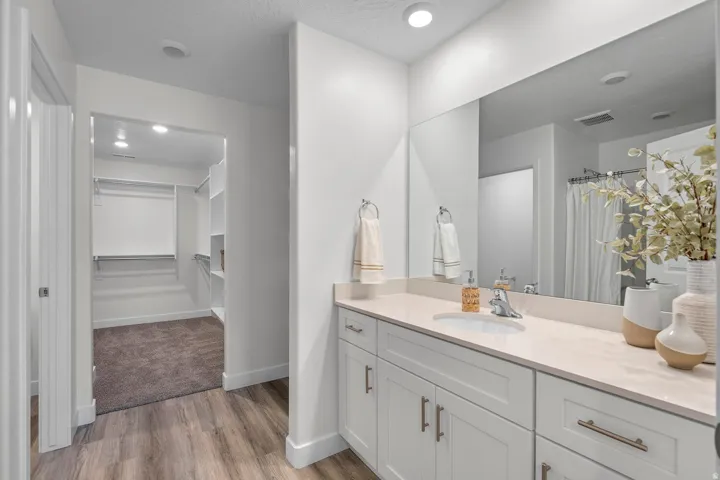 Spacious vanity with dual sinks, extensive countertop space, and large mirror