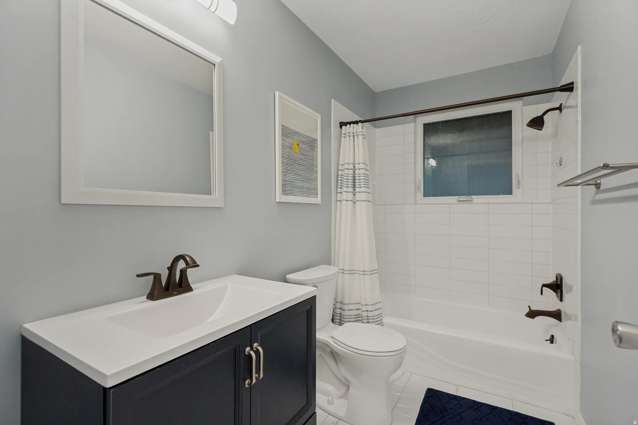 Integrated vanity with a white countertop and bronze-finish faucet