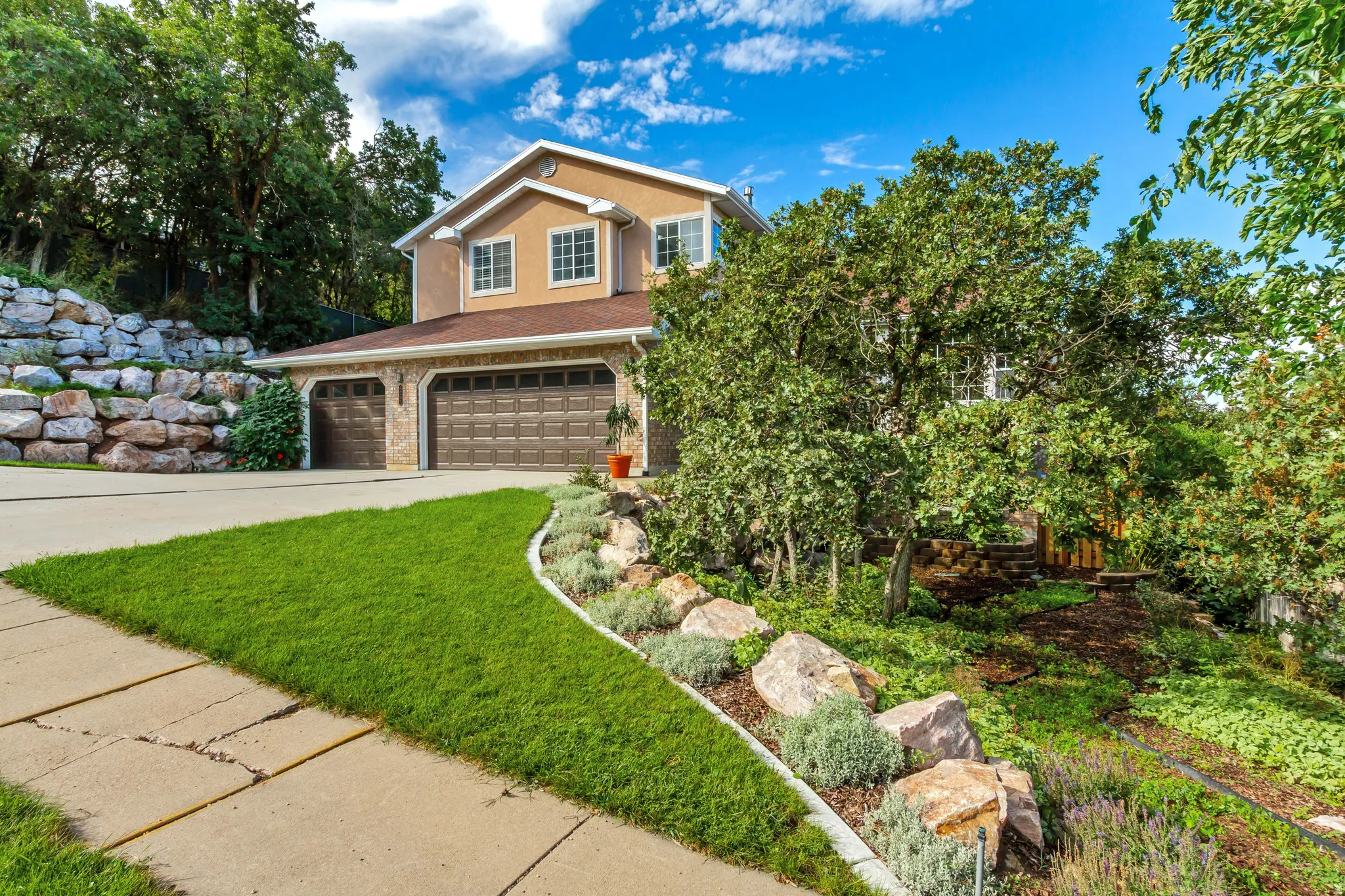 Stucco exterior with multiple windows, an attached two-car garage, and a concrete driveway