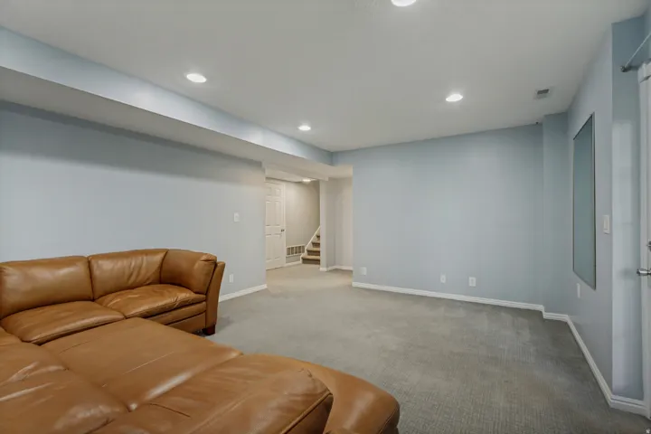 Recessed lighting, light blue wall paint, gray carpet flooring, white trim, and white paneled doors