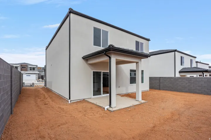 Two-story stucco exterior with a covered patio and sliding glass door