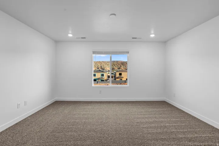 Recessed lighting, neutral wall finishes, and a window with blinds