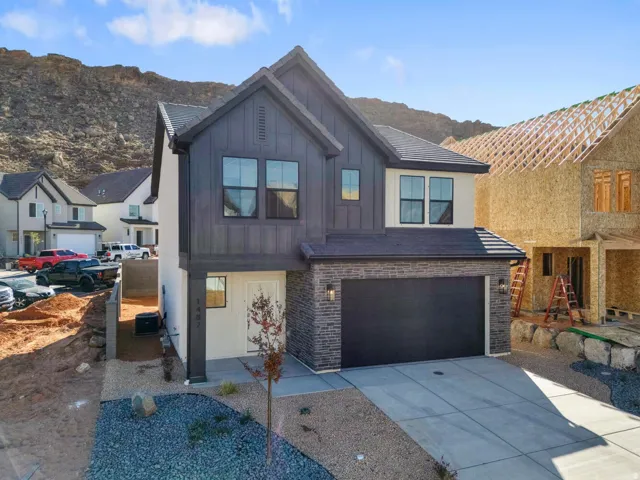 Contemporary exterior with vertical dark siding, stone veneer accents, and a two-car garage