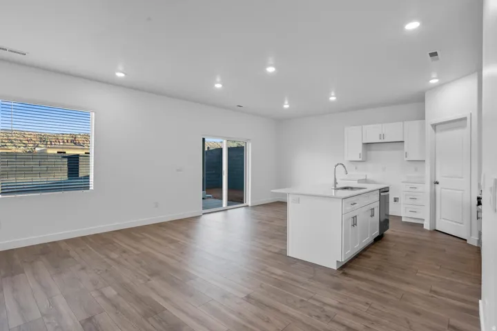 Open concept living area featuring wood-finish flooring, recessed lighting, and a sliding glass door