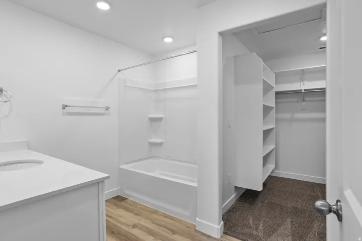 Bathroom with white vanity, integrated sink, and white countertop