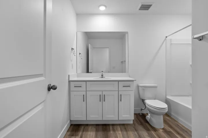 White vanity with cabinet storage, integrated sink, and white countertop