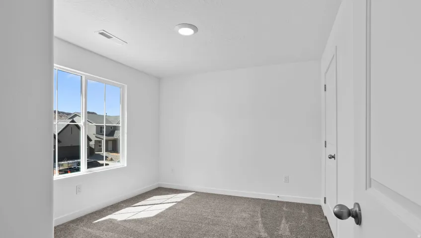 Recessed ceiling lighting, white interior walls, window with multiple panes, gray carpet flooring, and white trim
