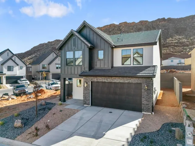 Modern two-story exterior with vertical siding accents, stone veneer detailing, and an attached two-car garage