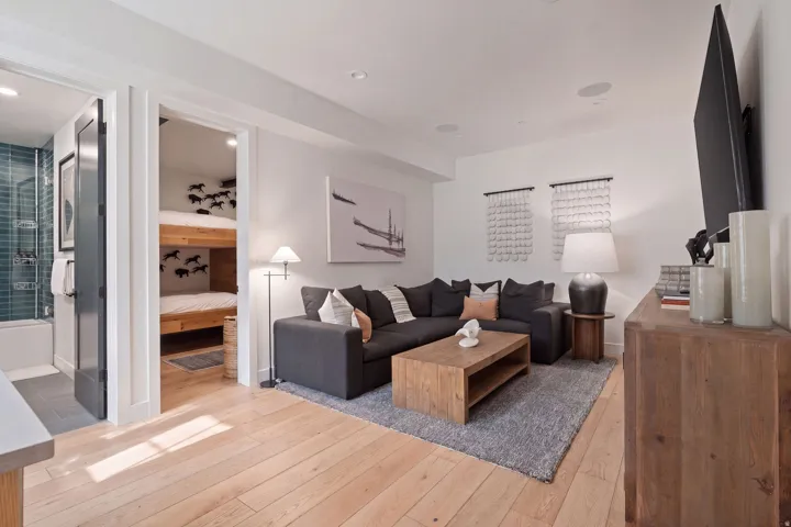 Wood-finish flooring throughout, recessed ceiling lighting, built-in ceiling speakers, and a white wall finish