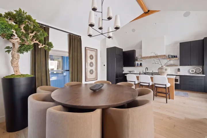 Open-concept living space with a vaulted ceiling and exposed wood beam