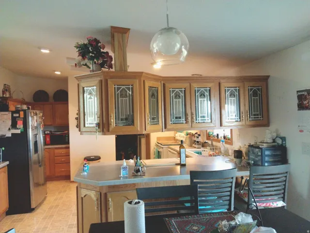Kitchen featuring wood cabinetry, integrated appliances, and a peninsula countertop