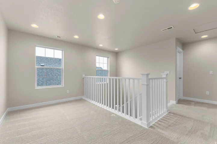 Loft area featuring neutral carpeting and recessed lighting
