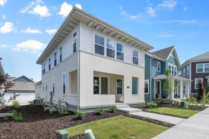 Two-story exterior with a cream stucco finish and white horizontal siding