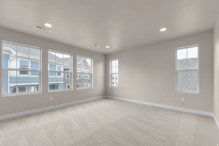 Neutral-toned walls, recessed lighting, wall-to-wall carpeting, and multiple windows
