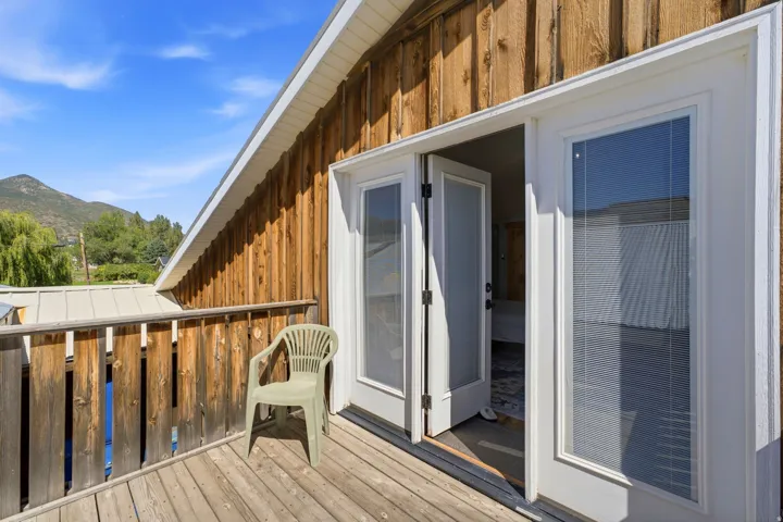 Wood-paneled exterior with a private balcony featuring wooden decking and railings