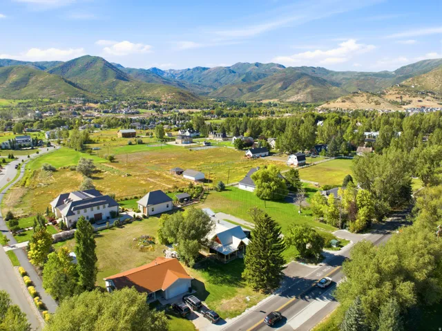 Expansive landscape featuring distant mountains, surrounding green hills, and varied residential architecture