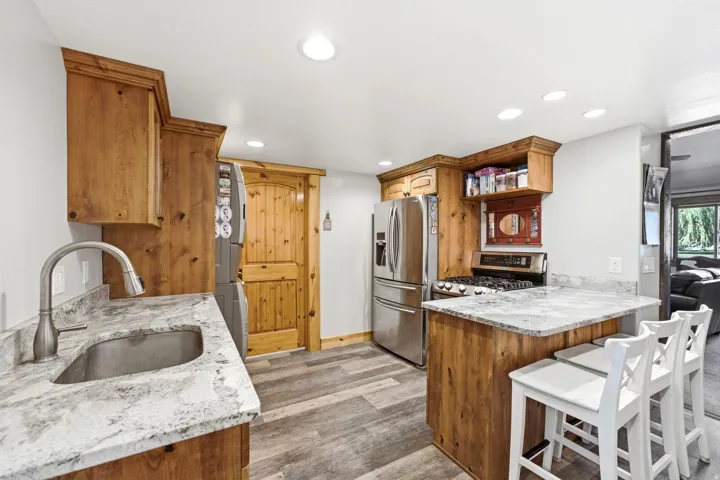 Wood-finish cabinetry paired with light-toned countertops and wood-finish flooring