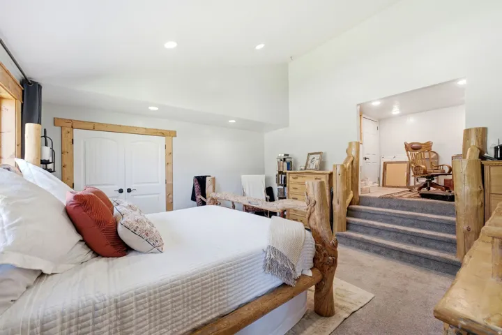 Raised ceiling, recessed lighting, double panel doors with wood trim, built-in wooden staircase with carpeted treads