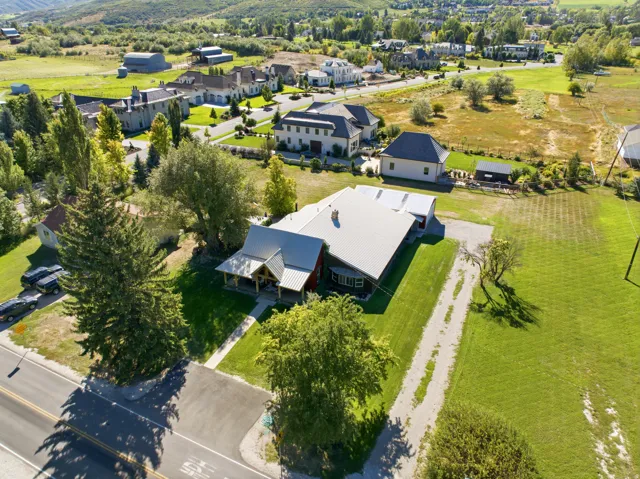 Property featuring a metal roof, a covered porch with exposed beams, and a gravel driveway