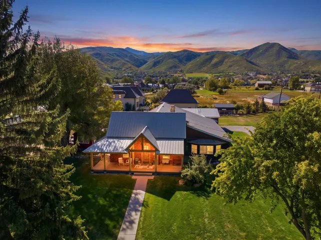 Mountain backdrop, expansive lawn, covered front porch, metal roof, bay window