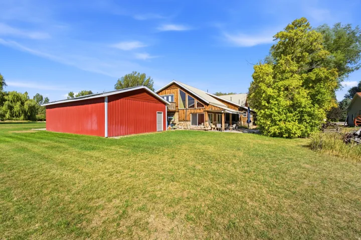 Expansive green lawn with a red attached garage