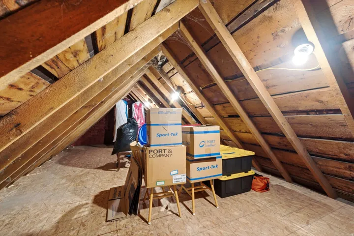 Attic storage space featuring exposed wood beams and subfloor