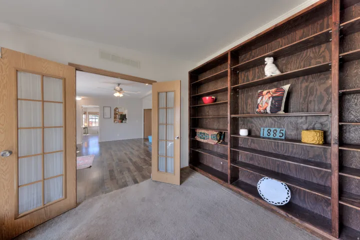 Built-in shelving, glass-paneled double doors, and wood-finish flooring