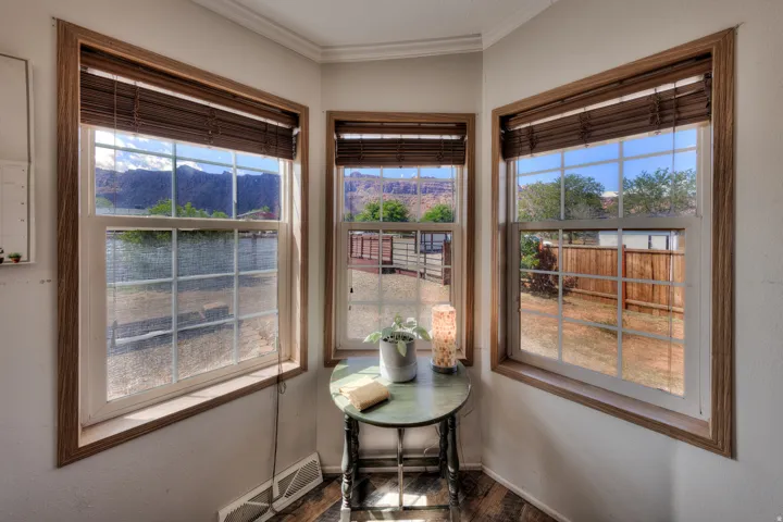 Corner window configuration with wood-finish trim, natural light, and varied outdoor scenery