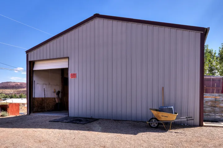 Metal utility building with a roll-up door, corrugated siding, and a sloped roof