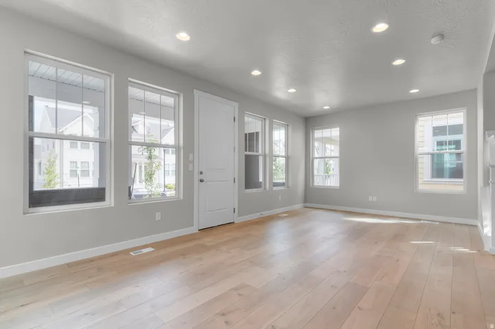 Hardwood-style flooring, white trim, recessed lighting, and multiple windows